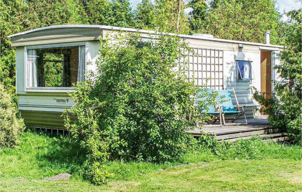 a small house with a porch and a deck at Gorgeous Stacaravan In Darlowo in Darłowo