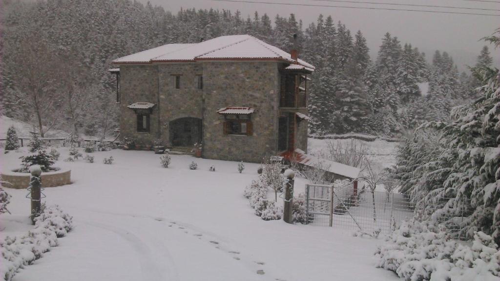un edificio cubierto de nieve en un patio en Guest House Pantos Kairou, en Karkaloú