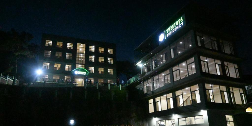a building with a sign on top of it at night at TreeTops Residency in Shillong
