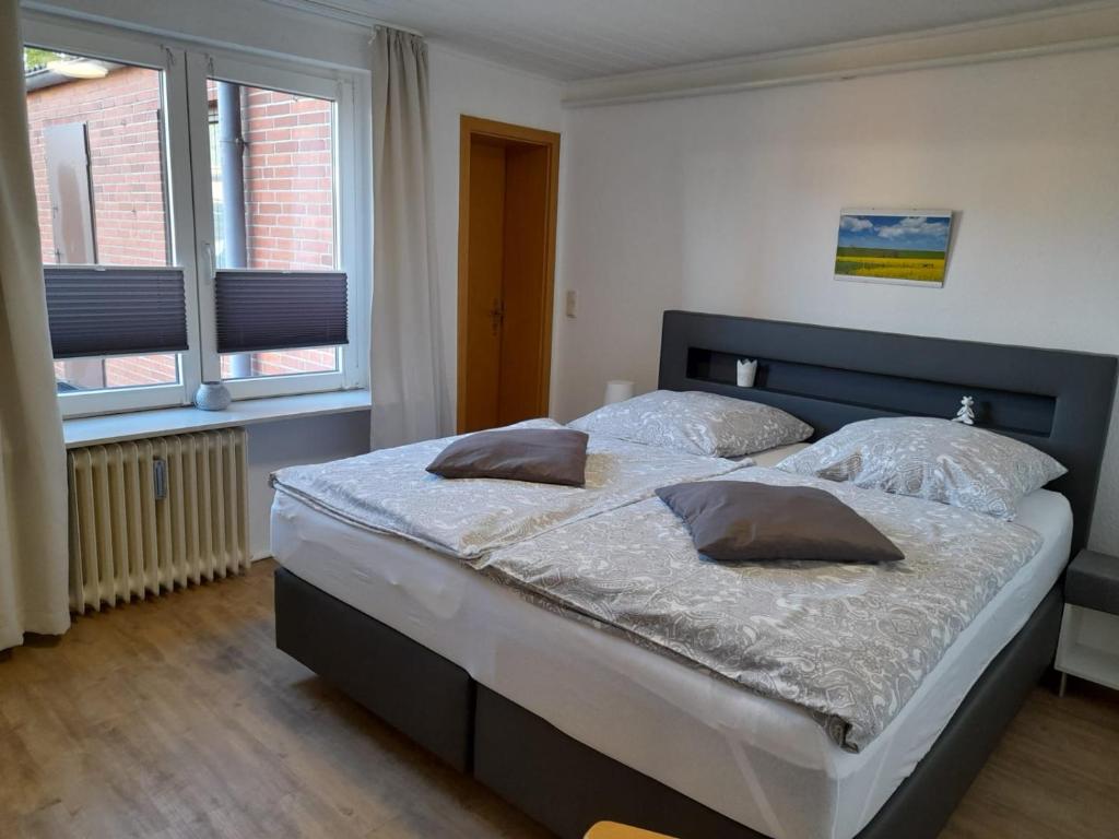 a bedroom with a large bed with two pillows on it at Haus Edel in Wesselburen