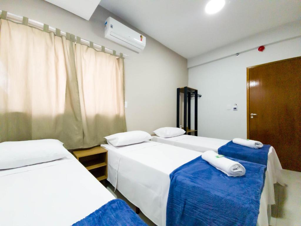 a room with two beds with blue and white sheets at HOTEL CONSAGRADO in Aparecida