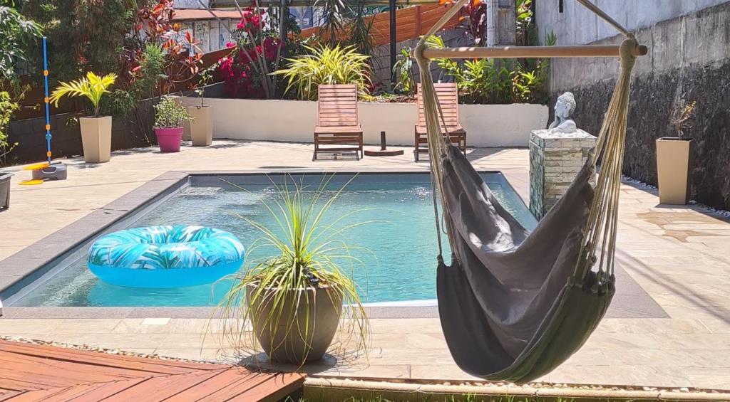 a pool with a hammock and two chairs and a pool at Villa Mahavel in Saint-Pierre