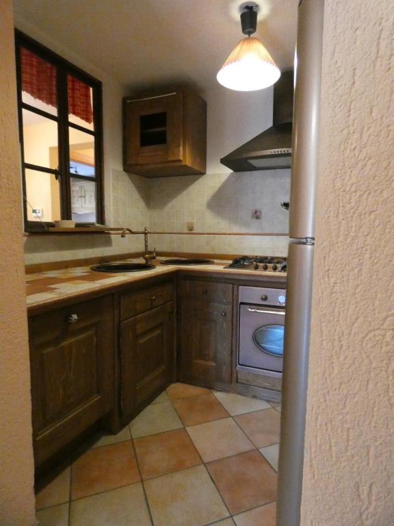 a kitchen with wooden cabinets and a sink and a stove at Au Coeur de Saint Nicolas in Saint Nicolas