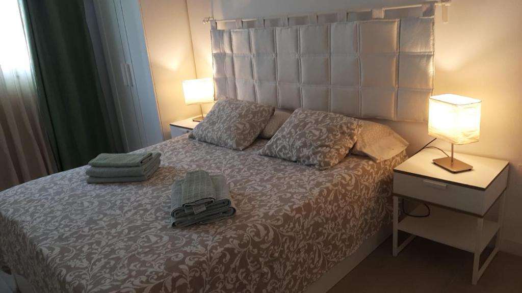 een slaapkamer met een bed met twee handdoeken erop bij Elegant apartment next to the sea! in Corralejo