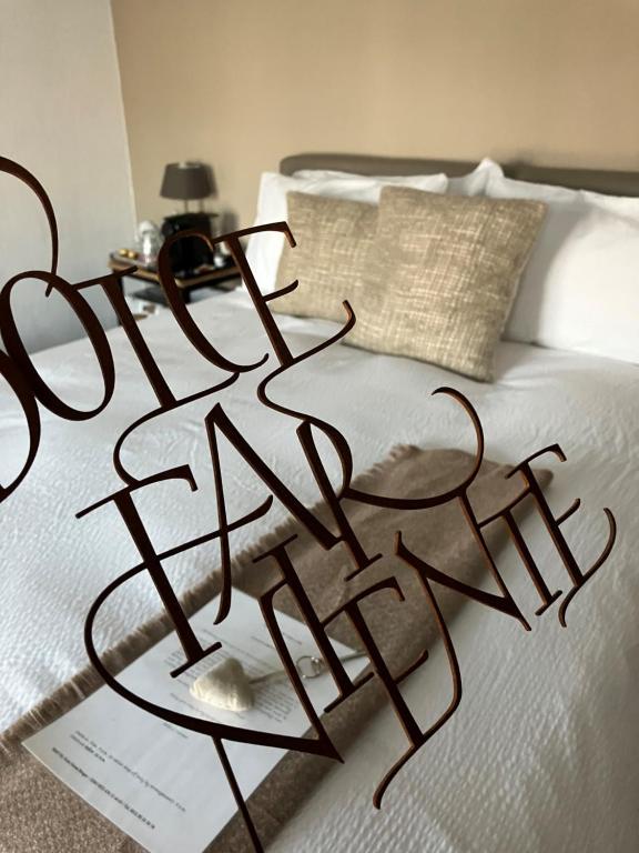 a sign on a bed that reads write reality at B&B My Suite Home in Bruges