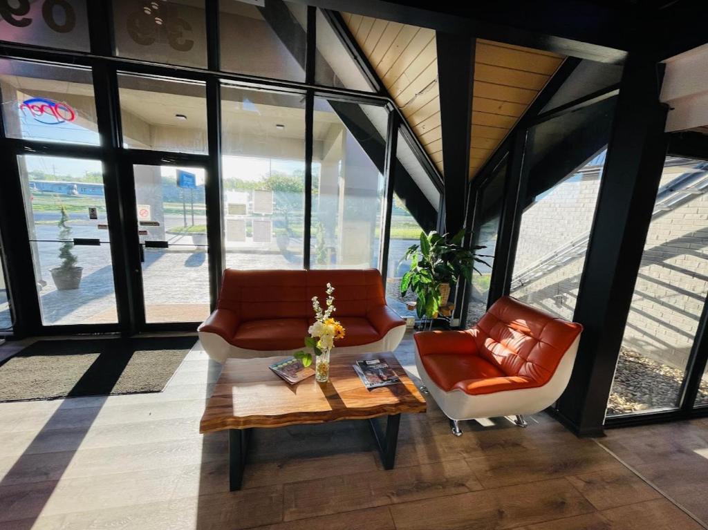 a living room with two chairs and a coffee table at Hotel Weston RFD in Rockford