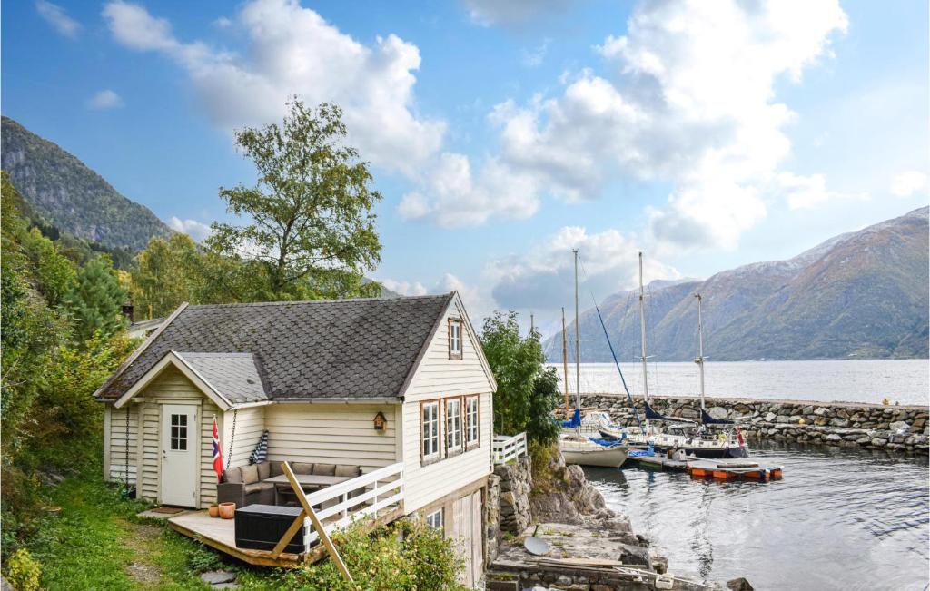 uma pequena casa ao lado de um corpo de água com barcos em Gorgeous Home In Vallavik With House Sea View em Kaland