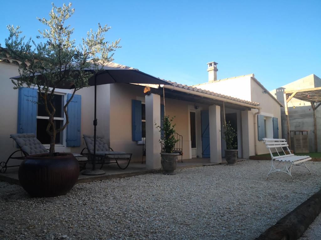 ein Haus mit einer Veranda mit einem Stuhl und einem Sonnenschirm in der Unterkunft Gîte paisible aux pieds des Alpilles, parking privé in Saint-Rémy-de-Provence