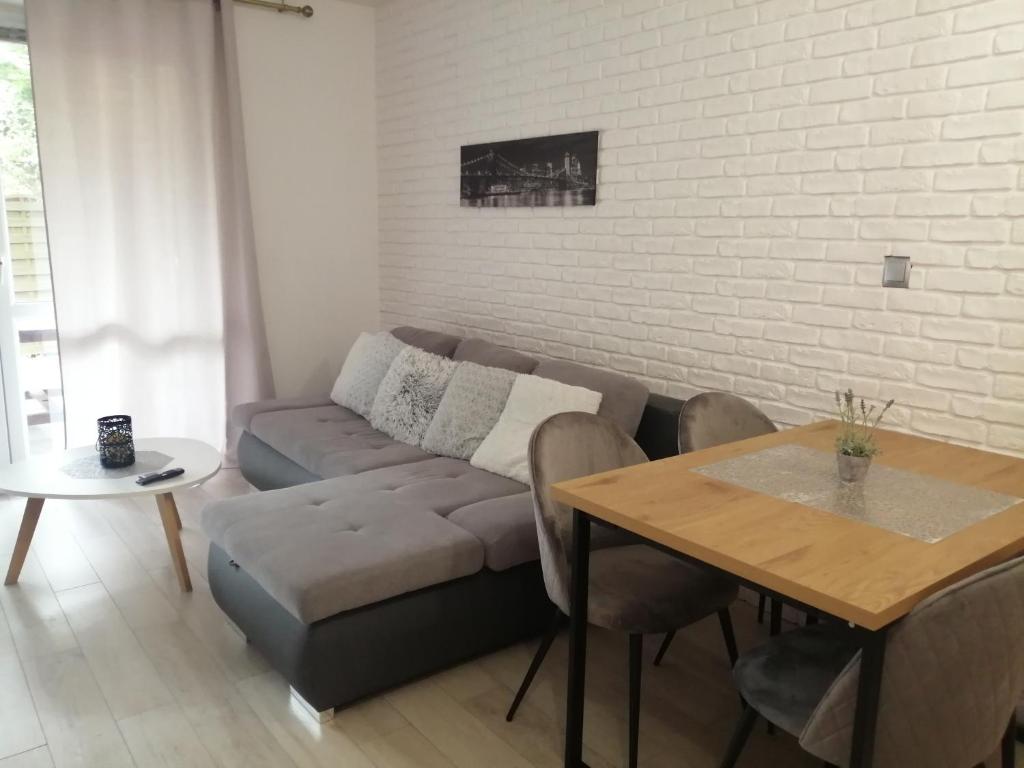 - un salon avec un canapé et une table dans l'établissement Apartament Lux Monika Rewal z tarasem i garażem, à Rewal