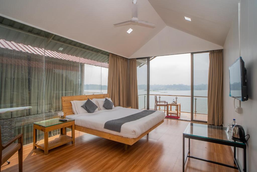 a bedroom with a bed and a large window at Shvas Island Resort in Igatpuri
