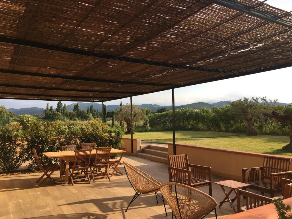 patio con mesa, sillas y vistas en Location de gîte - Mas catalan (66), en Camélas