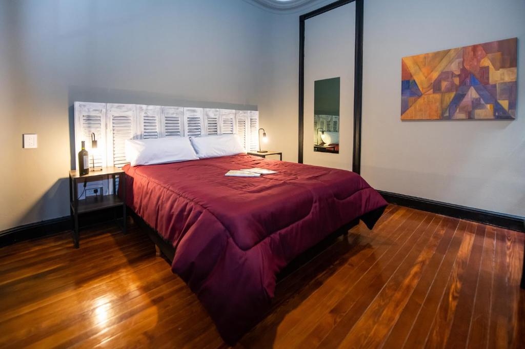1 dormitorio con 1 cama grande con manta roja en Maison Ramón en Buenos Aires