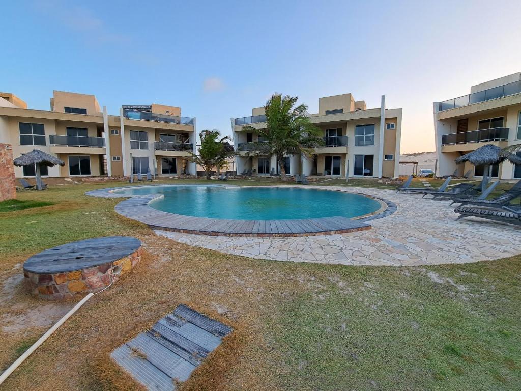 a swimming pool in front of a building at Vilas Na Praia Residence Condomínio in Canoa Quebrada