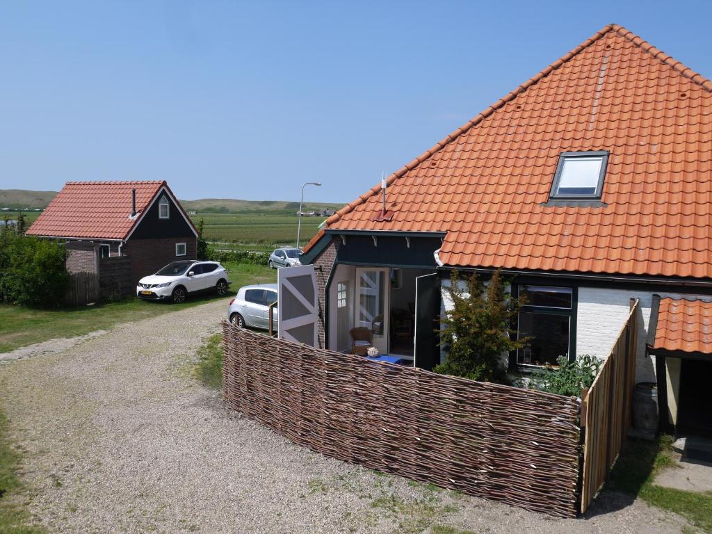 una casa con una valla delante de ella en de Dars, en Callantsoog