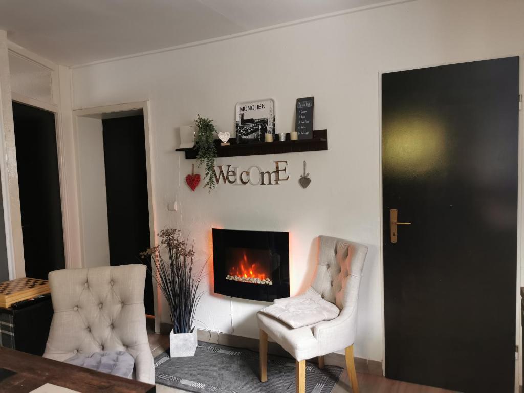 - un salon avec deux chaises et une cheminée dans l'établissement Wohnen im Ampertal in Grafrath, à Grafrath