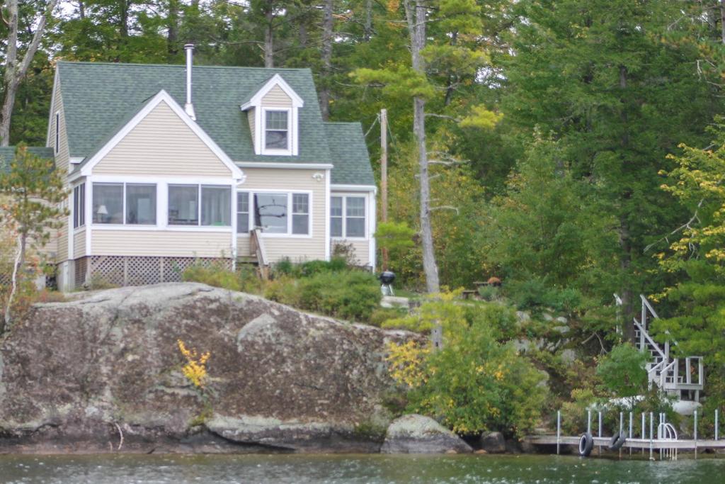 a house on the shore of a body of water at Waterfront Delight at Spindle Point in Meredith