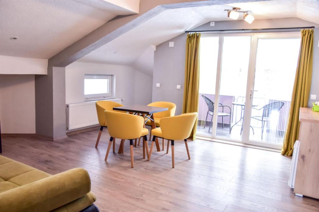 een woonkamer met een tafel en gele stoelen bij Papi Apartments in Kruševo