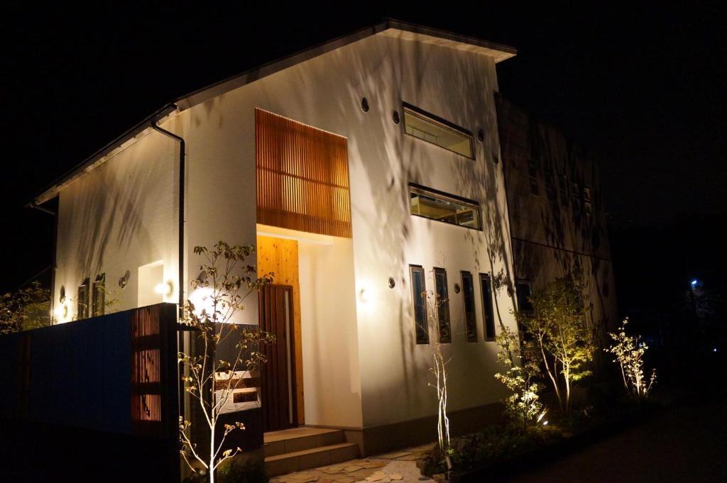 a white building with a door at night at SORAYADO 宙宿 in Tsuru 