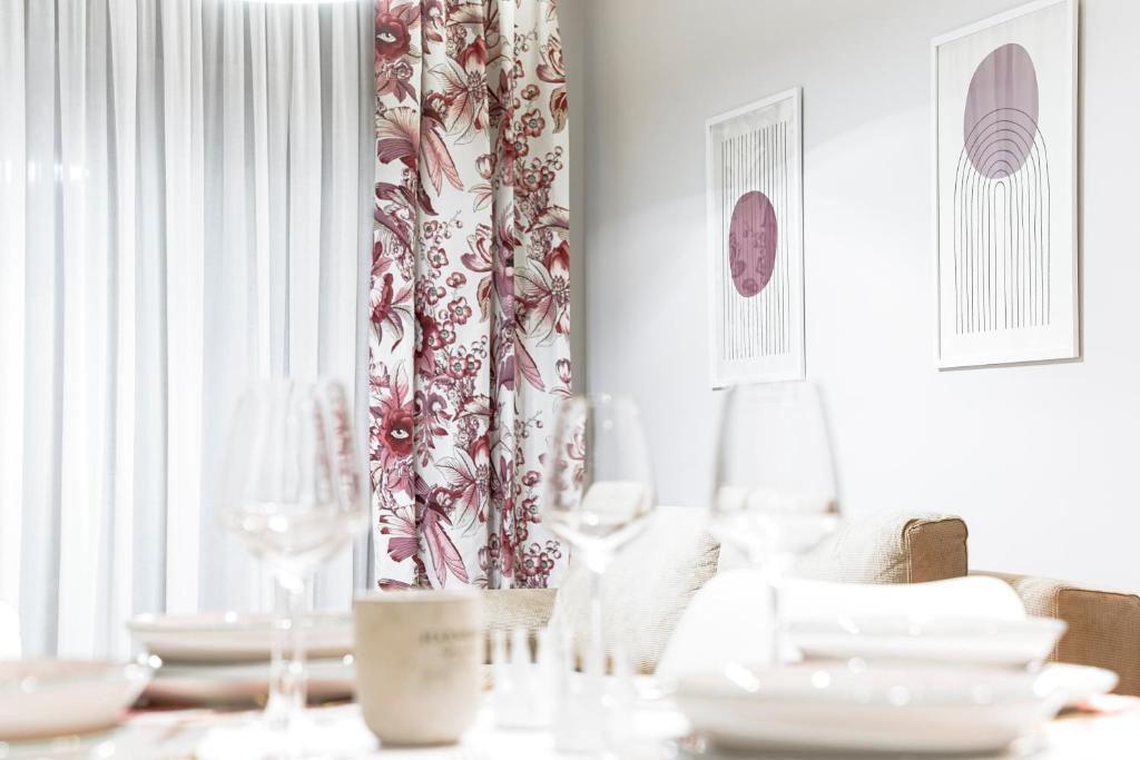a dining room with a table with plates and wine glasses at Quattro Luxury Apartments in Tríkala