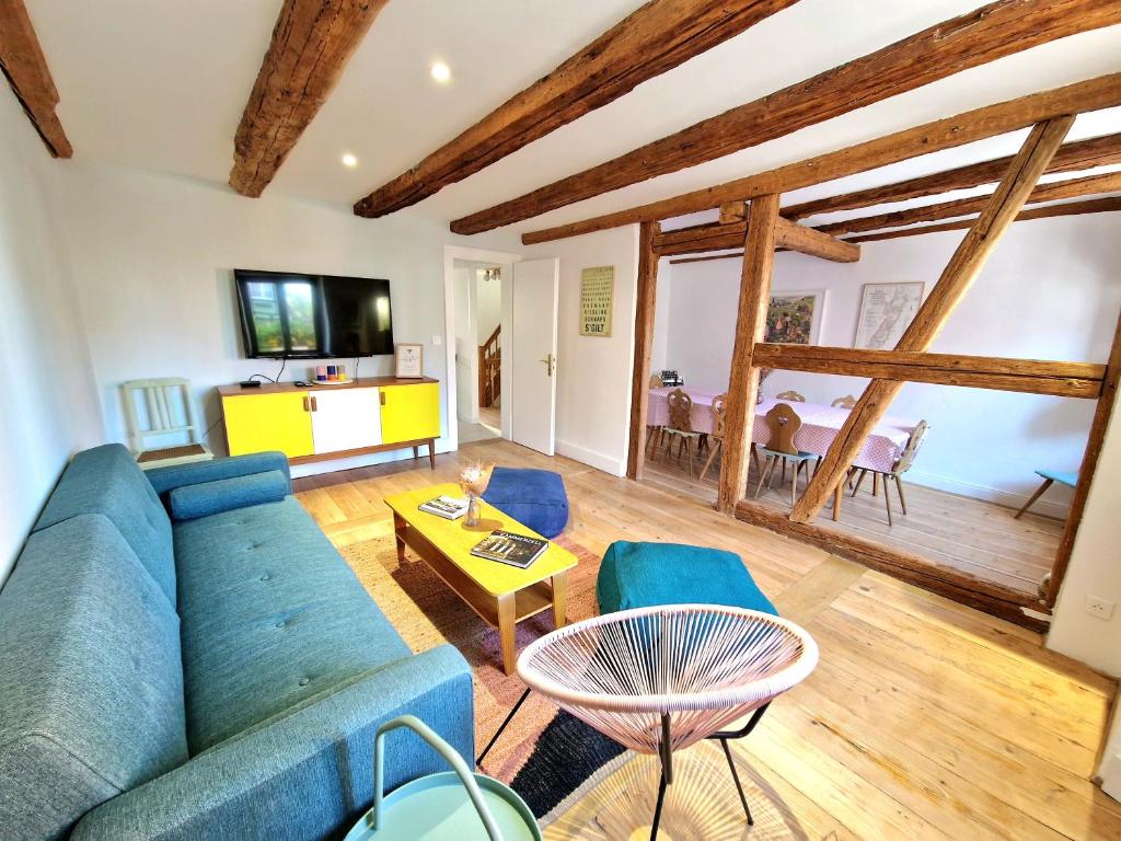 un soggiorno con divano blu e tavolo di Home La Petite Porte - Petite Venise - Colmar a Colmar