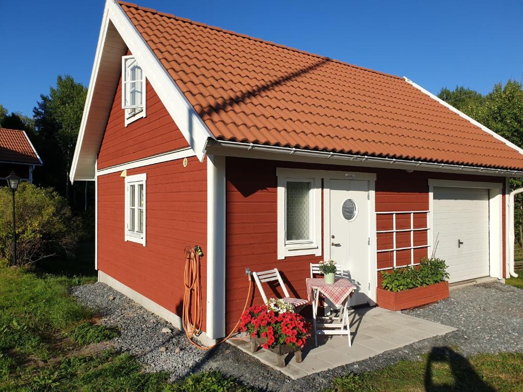 a red and white shed with a table and a chair at Carlberg Rum Loftet in Bergshamra