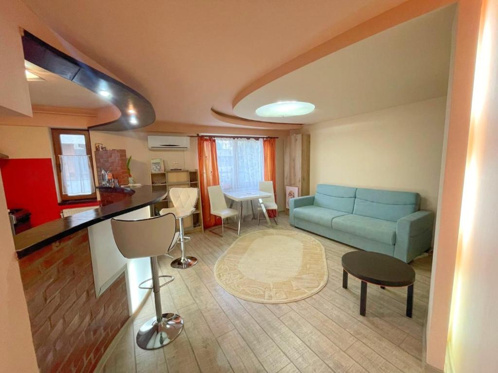 uma sala de estar com um sofá azul e uma mesa em Ultracentral Lozonschi 2 rooms apartment em Iaşi