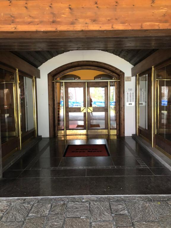 een toegang tot een gebouw met een lobby met glazen deuren bij Appartamento per max 6 pers nel centro di San Martino di Castrozza n 31 in San Martino di Castrozza
