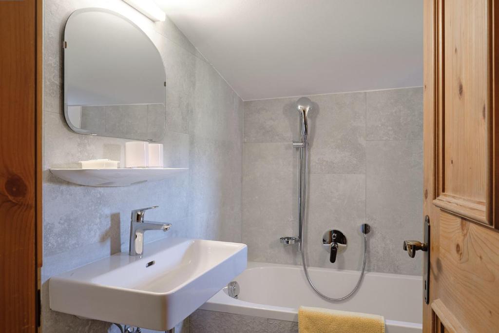 bagno bianco con lavandino e doccia di Pension Landhaus Gasteiger a Kitzbühel