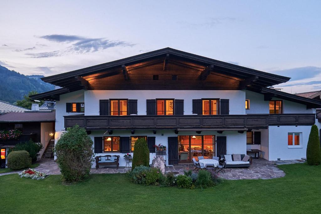 a large white house with a gambrel roof at Pension Landhaus Gasteiger in Kitzbühel