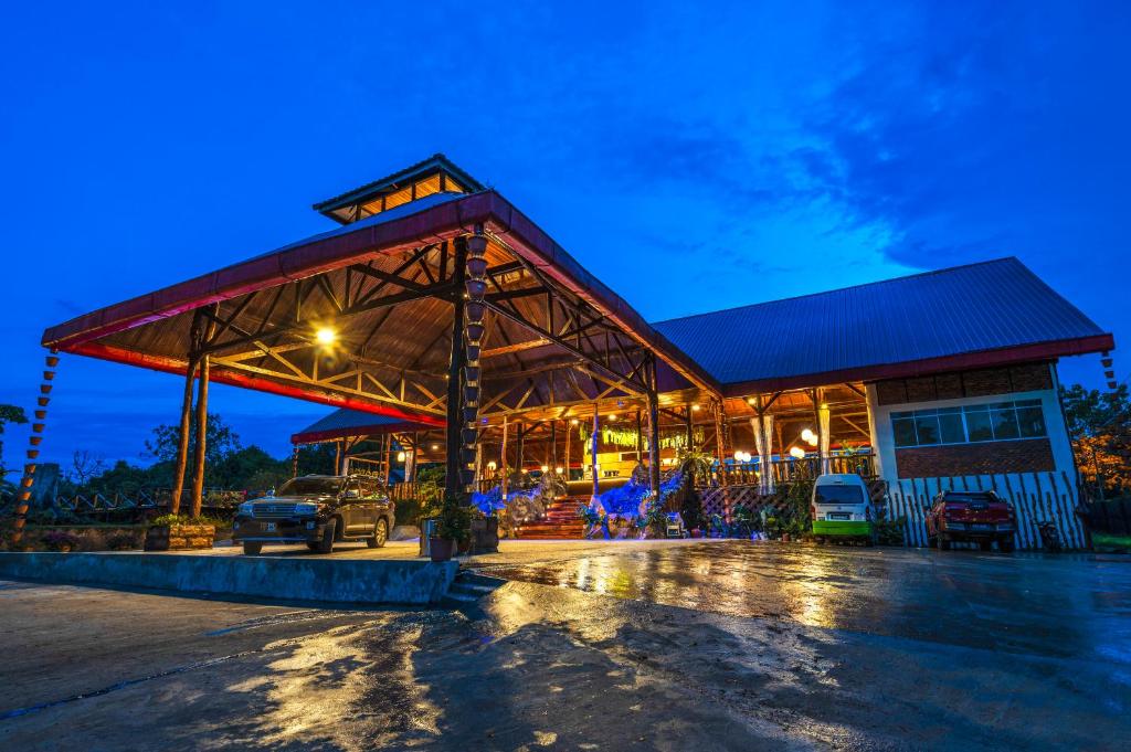 parking z budynkiem z samochodami zaparkowanymi w nim w obiekcie Borneo Sepilok Rainforest Resort w mieście Sepilok