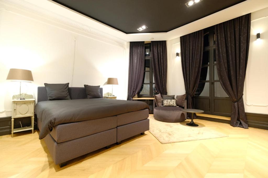 1 dormitorio con 1 cama, 1 mesa y 1 silla en Suite la Duchesse et Parking privé gratuit, en Mons