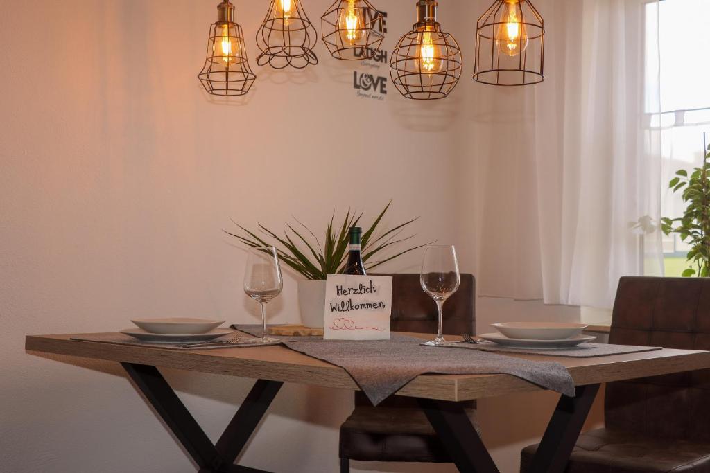 een tafel met twee glazen en een fles wijn bij Buchen Blick - Ruhige moderne Ferienwohnung 82qm. in Fichtelberg