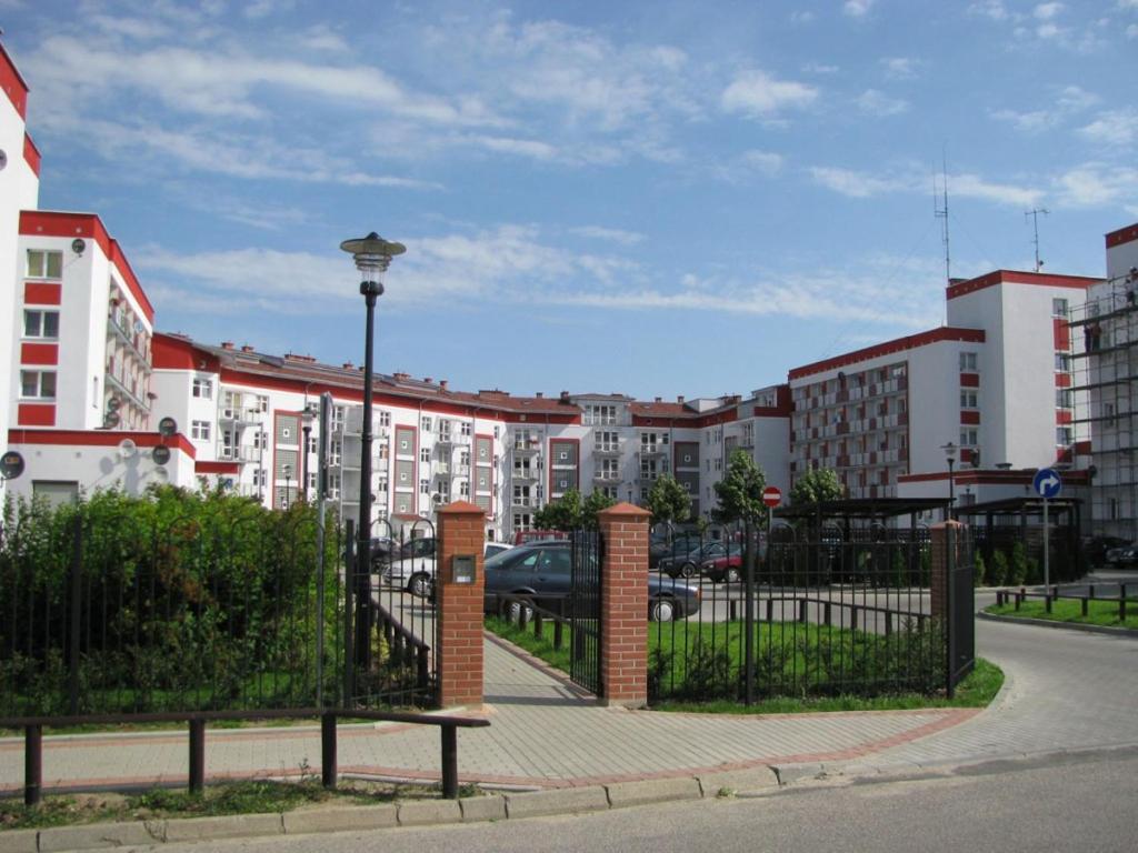 uma cerca de ferro forjado com um portão numa cidade em Apartament W sam Raz em Słupsk