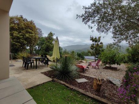 a patio with a table and a umbrella at appartement coubillou in Lamalou-les-Bains