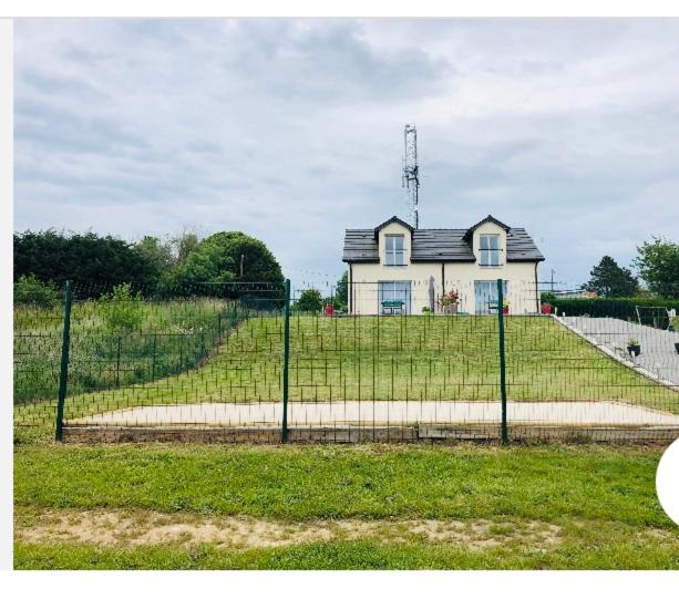 einen Zaun vor einem Haus auf einem Feld in der Unterkunft Les coteaux vue mer in Criel-sur-Mer