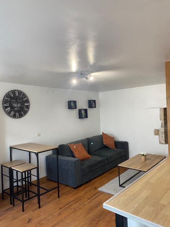 sala de estar con sofá y reloj en la pared en Appartement Chaumont en Chaumont