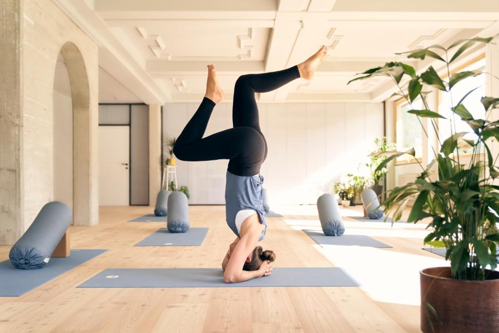 una mujer haciendo una pose de yoga en una clase de yoga en Design Apartments & Zimmer - Zugspitze, en Leutasch