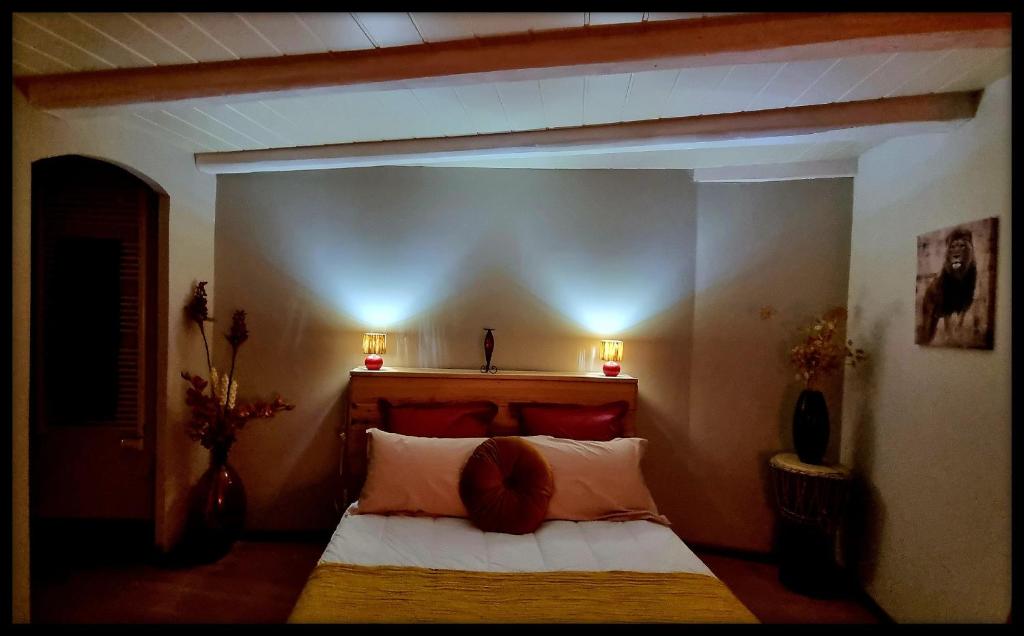 a bedroom with a bed with two lamps on the wall at Les Jardins de Kuz - Lion in Bernin