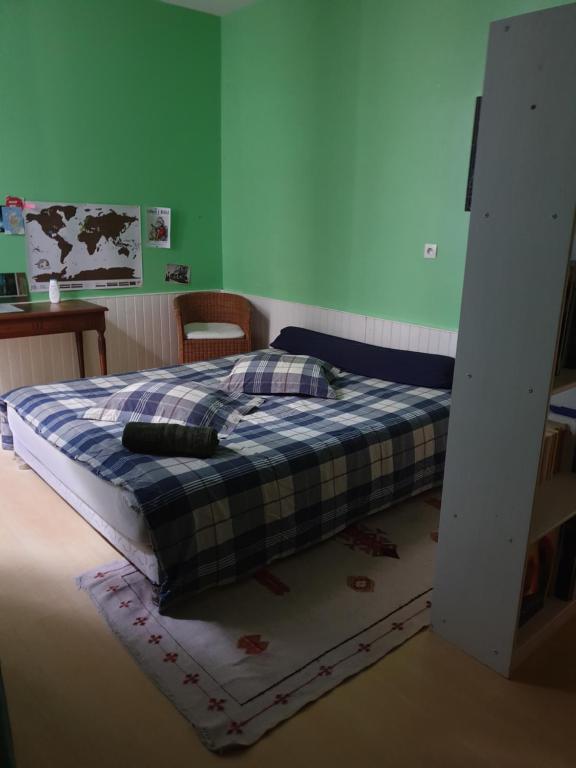 a bedroom with a bed with a plaid blanket at La Demeure in Gabarret