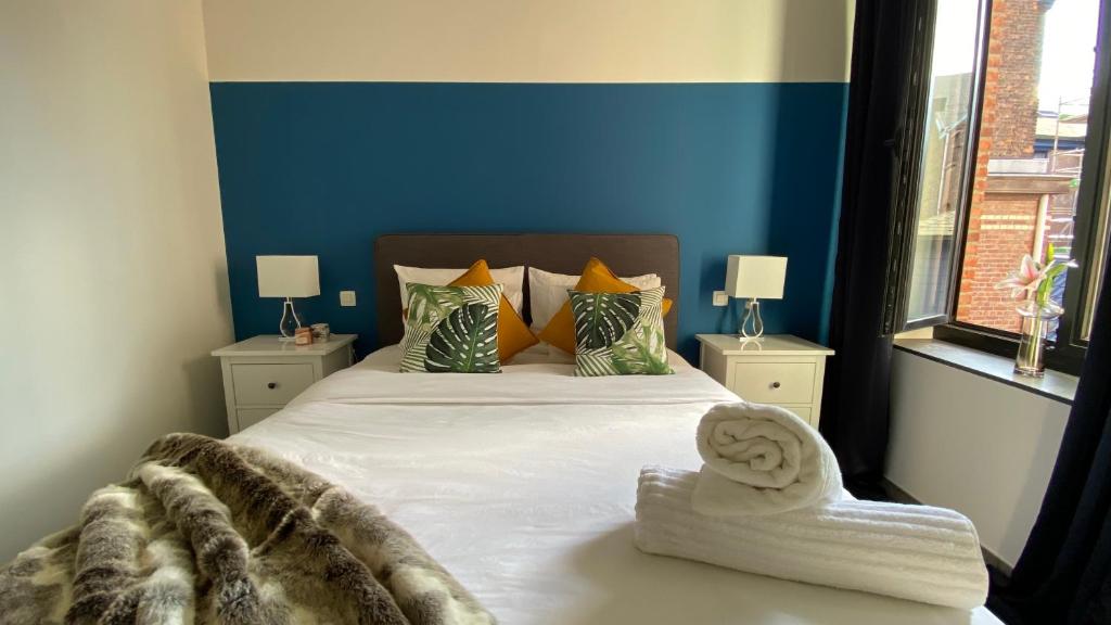 una camera con un grande letto con una parete blu di Oneluxstay Antwerp City Centre ad Anversa