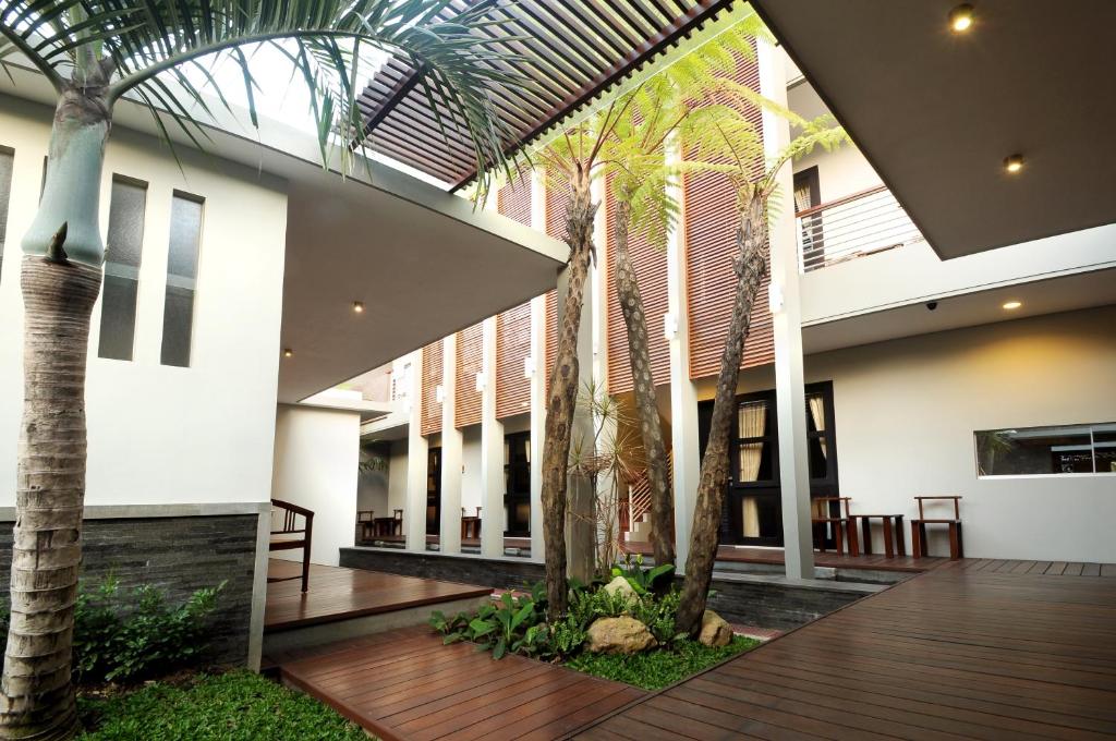 un patio con palmeras en un edificio en COZY Boutique Guest House, en Malang
