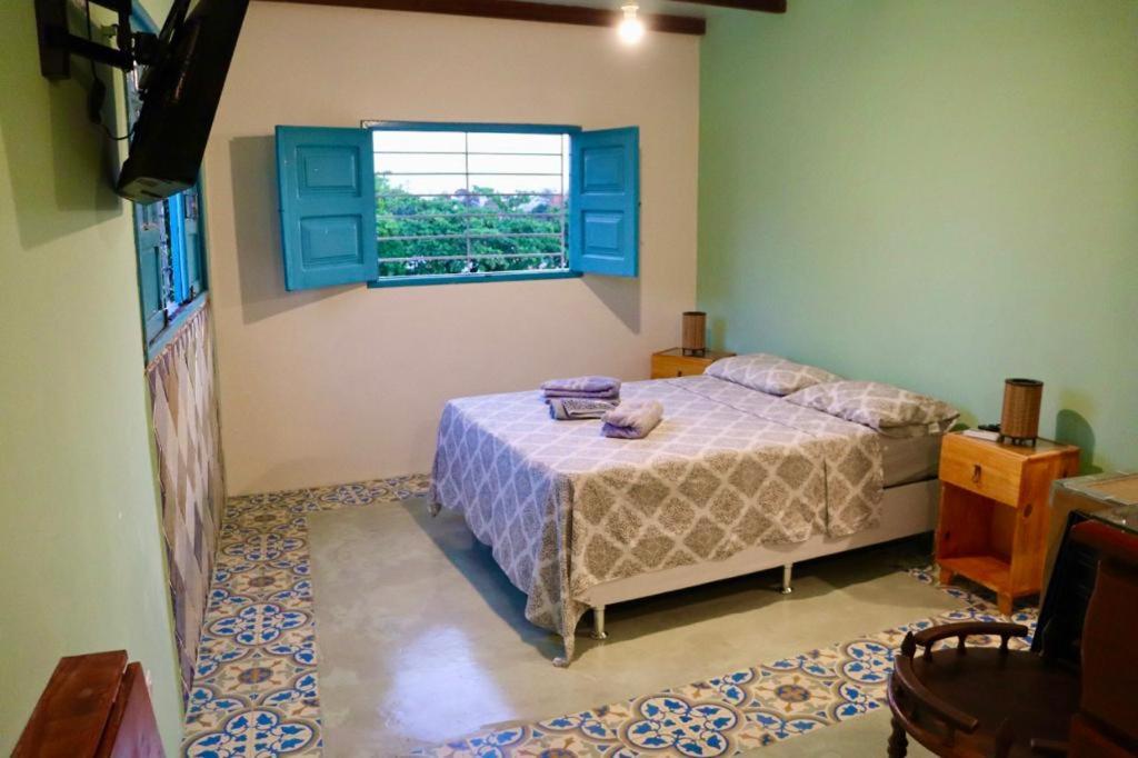 un dormitorio con una cama y una ventana en Estúdio dos sonhos com bela vista próximo ao alto da sé, en Olinda