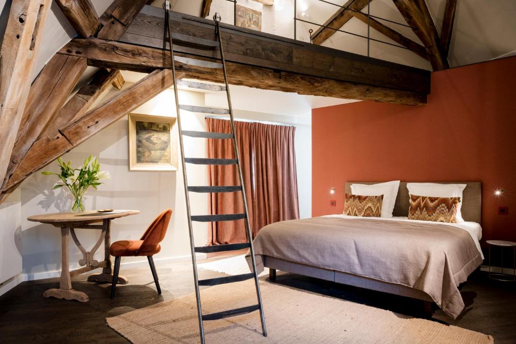 una camera da letto soppalcata con letto e scala di B&B l'histoire de l'éclair a Bruges