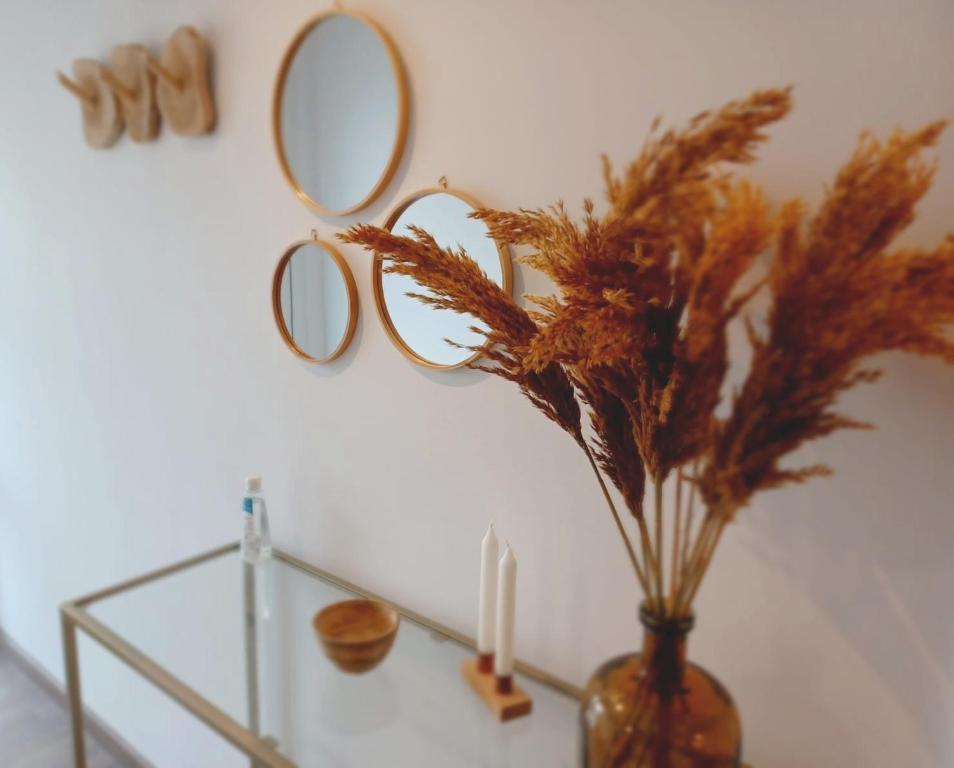 a vase with a candle and a mirror on a wall at AMS Appartement Spaichingen in Spaichingen