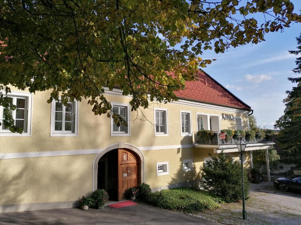 een groot geel huis met een bruine deur bij Hotel Die Residenz in Schloss Rosenau
