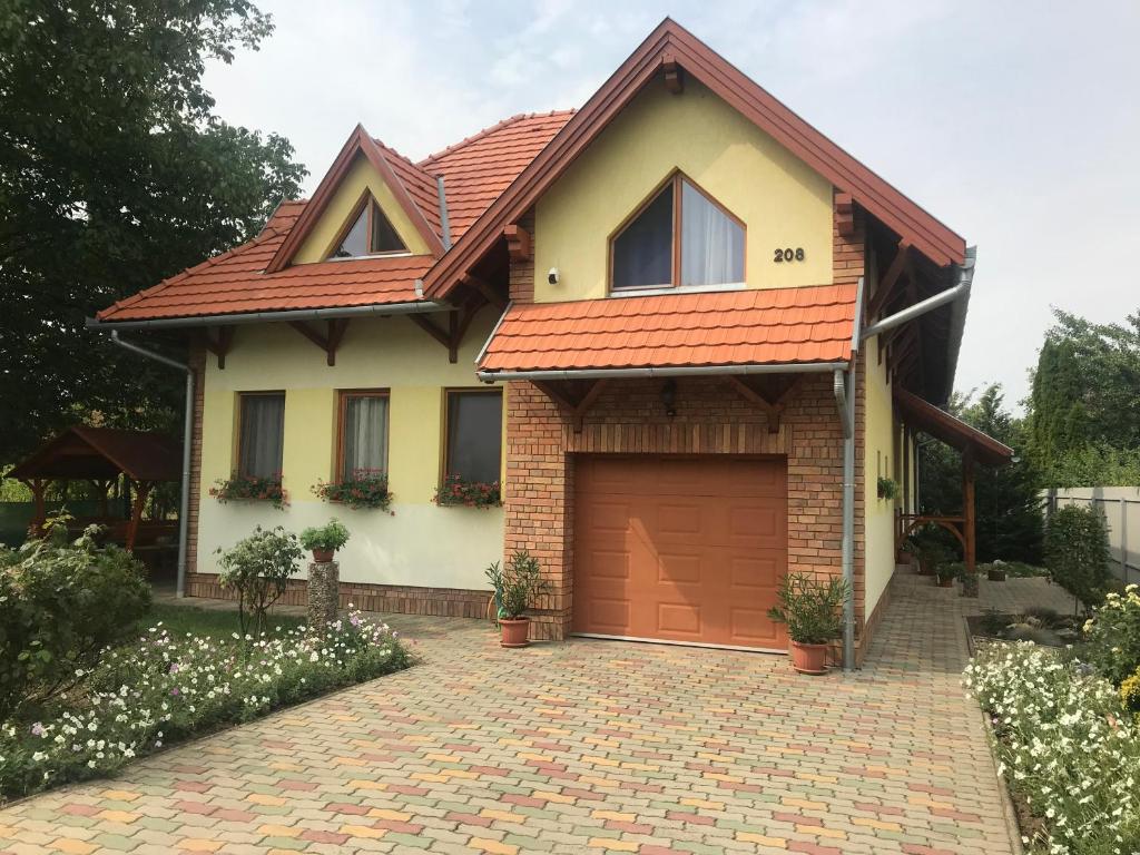 a house with a brick driveway and a garage at Napfény apartman in Orosháza