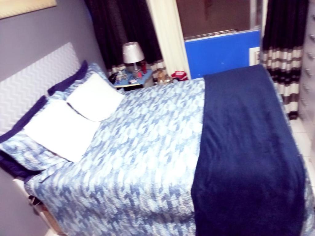 a bedroom with a bed with a blue comforter at Lindinho apartamento Copacabana in Rio de Janeiro