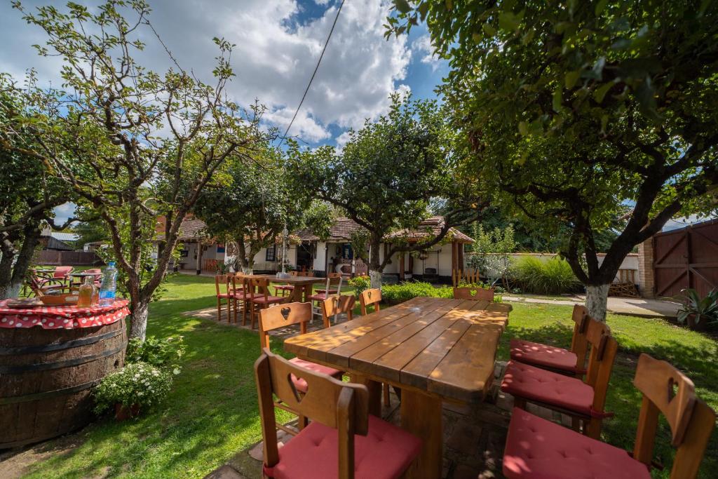 a wooden table and chairs in a yard with trees at Domacinstvo Cikic Zasavica in Zasavica