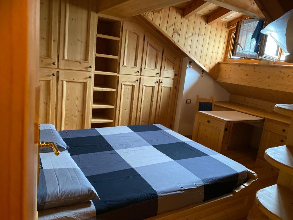 um quarto com uma cama azul e branca num camarote em Precumon 16/5 em Arabba