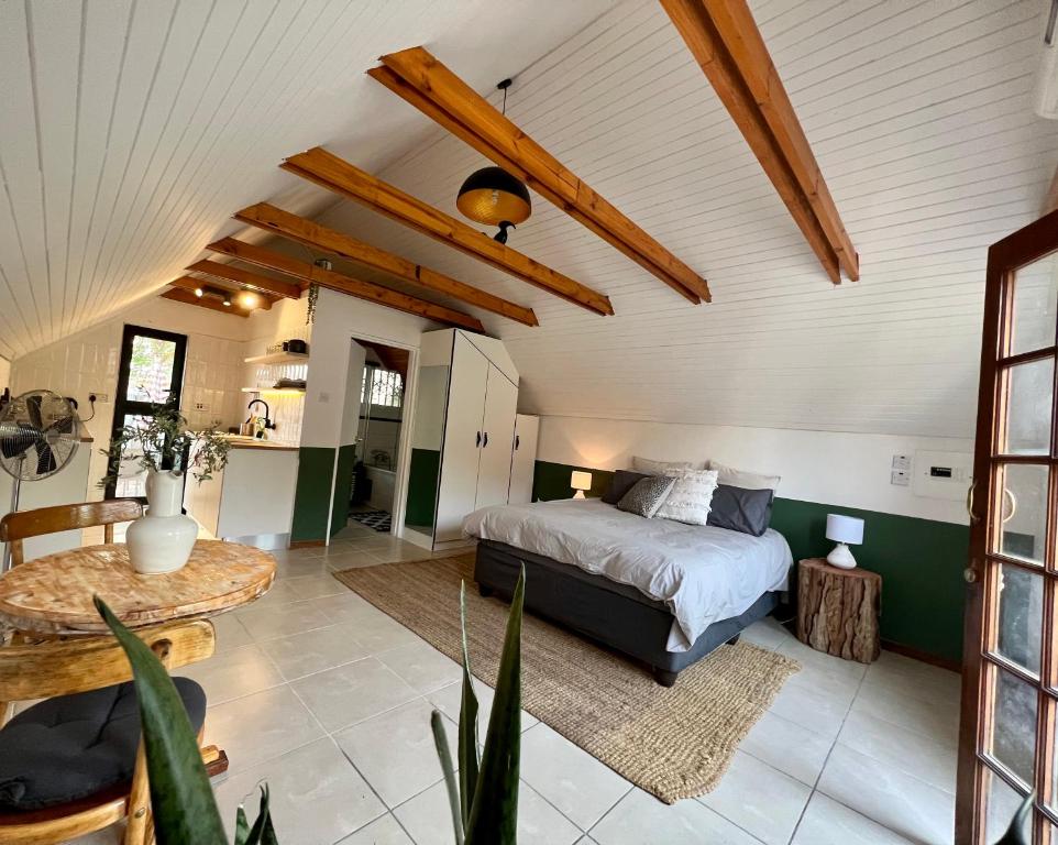 um quarto com uma cama e uma mesa num quarto em Cosy City Cottage em Gaborone